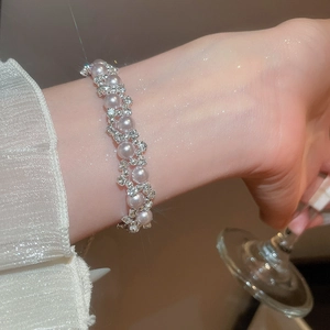 Close-up of pearl and zircon bracelet on wrist with elegant starlight filter effect