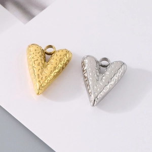 Vista dettagliata di ciondoli a cuore 3D oro e argento con finitura martellata materica