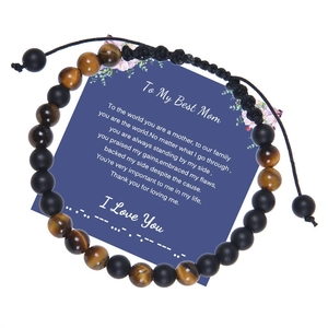Gros plan d'un bracelet en œil de tigre avec code Morse et carte de vœux cadeau