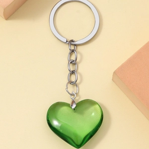 3D resin heart keychain with silver metal ring on a minimalist beige background
