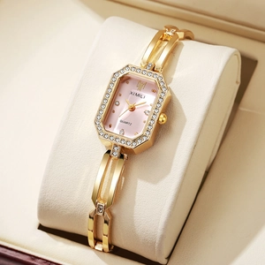 Détail d'une montre à quartz octogonale dorée avec cadran rose et lunette en cristaux