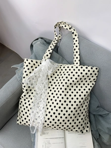 Close-up of retro polka dot canvas tote bag featuring an elegant lace ribbon bow detail