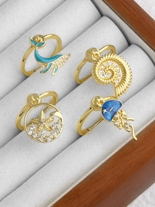 Detailed view of 18k gold plated ocean rings with whale and starfish enamel charms