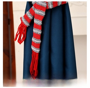 Détail d'embrasse de rideau de Noël tricotée à rayures rouges et grises avec franges