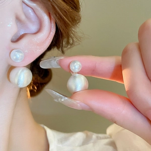 Vintage small faux pearl geometric stud earrings with matte gold finish on a model's ear