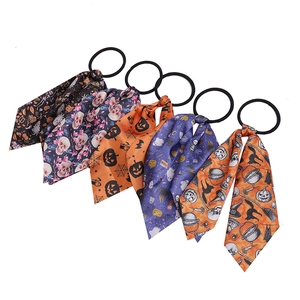 Halloween scrunchies with skull and pumpkin patterns arranged in a fan shape on white background
