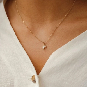Detail of 14K gold plated necklace featuring two baroque freshwater pearls on model