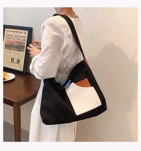 Canvas shoulder bag with brown and white patchwork pocket detail on a black body