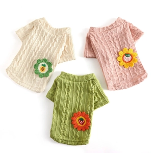 Chic cable-knit pet sweaters in cream, pink, and green with crochet fruit floral details