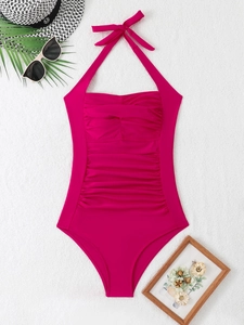 Detail of rose pink halter swimsuit featuring front ruching and elegant neck tie bow