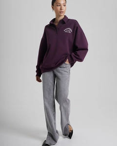 Detail of lavender oversized quarter-button sweatshirt with white varsity lettering