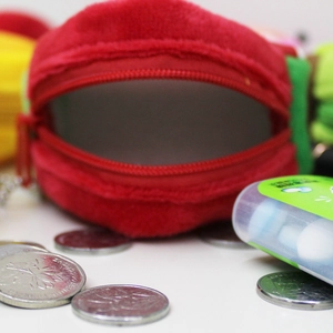 Detailed close-up of the red zipper opening on a round plush fruit coin purse