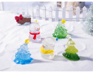 Miniature glass Christmas trees and tiny snowmen set in a snowy festive DIY scene