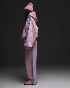 Détail latéral d'un ensemble survêtement rose avec dentelle bleue et bonnet