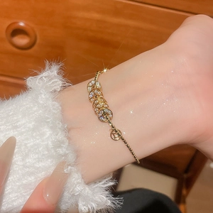 Nahaufnahme eines 18k vergoldeten Armbands mit funkelnden Kristallen am Handgelenk