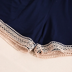 Detailaufnahme der marineblauen Schlafshort mit beiger Hohlspitze am Saum der Hose
