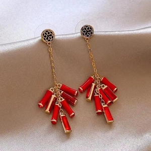Detailed close-up of Chinese style red tassel earrings with gold hollow patterns