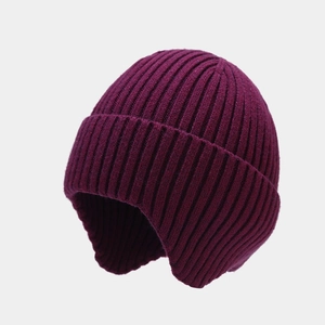 Close-up of burgundy ribbed knit texture on a winter trapper hat with ear flaps