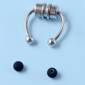 Macro detail of silver magnetic fake nose ring with interchangeable black ball ends