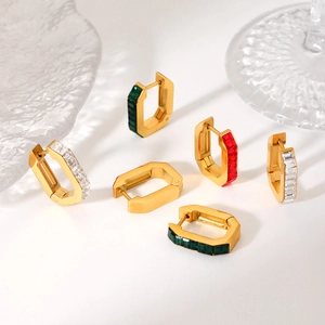 Detail of U-shaped gold earrings with inlaid square red, green, and white cubic zirconia
