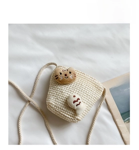 Detailansicht der Kinder Stroh-Eimertasche mit Plüschkatze und Fisch auf weißem Stoff