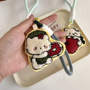 Close-up of cute plush cat charms with donut and strawberry embroidery and braided ropes