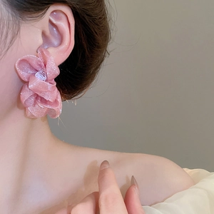 Detail of a large 3D pink chiffon flower earring with beads on a model side view