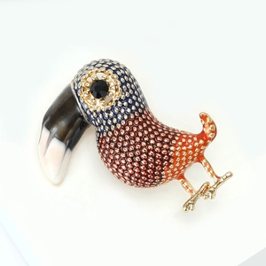 Detailed view of the toucan brooch with vibrant dot enamel and black rhinestone eye