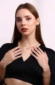 Close-up of elegant gold ribbon bow necklace and matching earrings set on model
