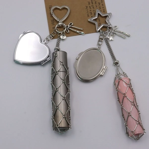 Detail of metal mesh lipstick holder keychain featuring a heart mirror and star carabiner