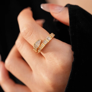Close-up of elegant gold snake-shaped ring with cubic zirconia on a model finger
