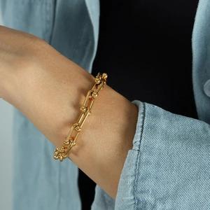 Polished 18k gold plated horseshoe U-link chain bracelet on a woman wrist