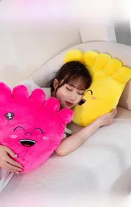 Close-up of soft plush big foot pillow featuring embroidered smiley face and cozy pink fabric
