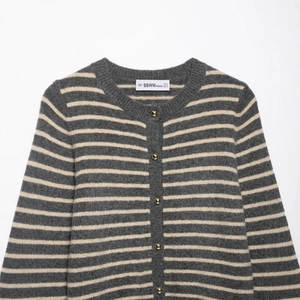 Women's grey and white striped knit cardigan with round neck and gold metal buttons