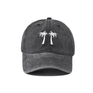 Detailed close-up of white palm tree embroidery on a vintage washed grey baseball cap
