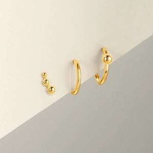 Close-up of golden S925 sterling silver geometric stud and minimalist hoop earring set