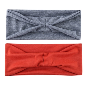Detail of grey and orange knitted sports headbands with a stylish crossover twist design