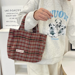 Detail of vintage plaid tote bag made of thick wool fabric with branded design label