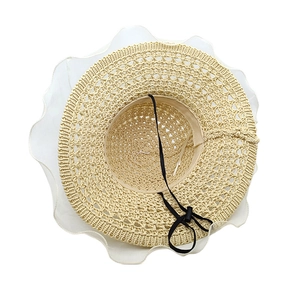 Detail of hand-woven straw sun hat with white wave lace trim and adjustable chin strap