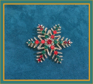 Detailed snowflake brooch with red and green crystals on gold-tone alloy base