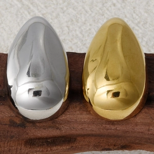 Macro shot of polished 18k gold and silver teardrop earrings on a wooden stand