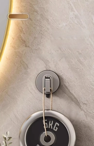 Detail of grey adhesive suction hook holding a 5KG weight on a marble wall