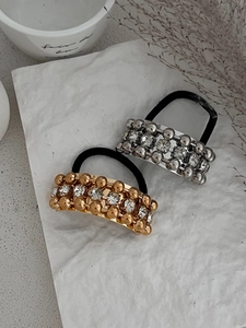 Close-up of gold and silver metal hair ties with sparkling rhinestones and elastic bands