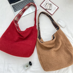 Flat lay of red wool and brown fleece tote bags with vintage plaid lining and essentials