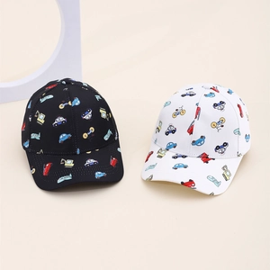 Detail of kids baseball caps featuring colorful cartoon vehicle prints on cotton fabric