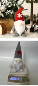 Detail of 70g Christmas gnome plush doll with red snowflake hat on an electronic scale