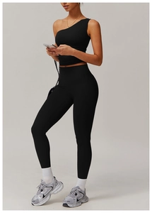 Détail du haut de sport à une épaule et du legging de yoga taille haute noir