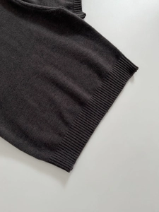 Close-up of charcoal gray knit fabric texture with high-quality ribbed hem detail