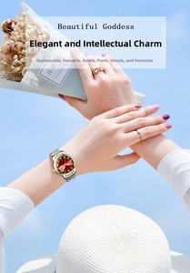 Fashion watch with red round dial and two-tone metal strap against a clear blue sky