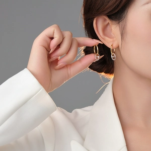 Fashionable gold hoop earrings with silver link pendant shown in professional model shot